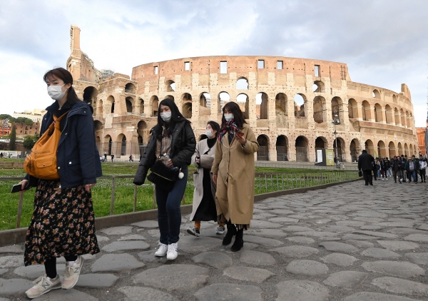 마스크를 쓴 관광객들이 한산해 보이는 이탈리아 로마의 원형경기장 콜로세움을 둘러보고 있다. 뉴시스