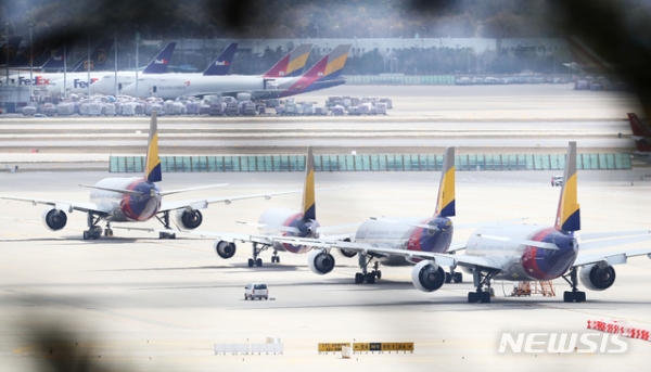 산업은행과 수출입은행이 코로나19 사태로 재정난을 겪는 아시아나항공을 추가 지원하기로 결정한 지난 21일, 인천국제공항 주기장에 아시아나항공 여객기들이 주기돼있다.뉴시스