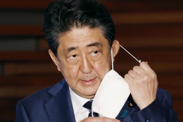 아베 신조 일본 총리가 지난 5월 21일 기자회견에서 마스크를 벗고 있다.AP·뉴시스