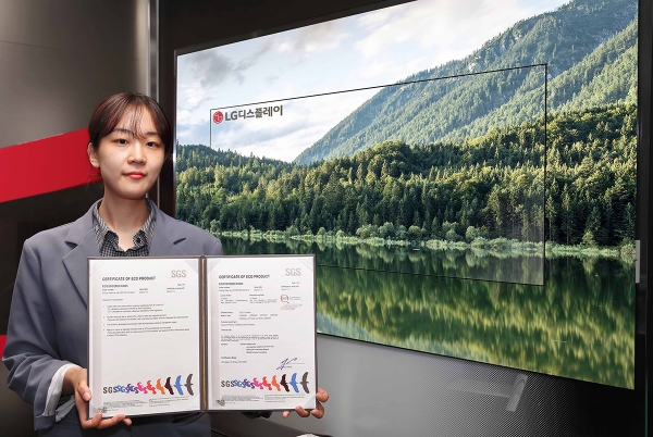 LG디스플레이의 OLED TV 패널이 스위스 검사·인증기관 SGS로부터 친환경 제품 인증을 받았다. 사진은 LG디스플레이 직원이 OLED TV 앞에서 SGS 인증서를 들고있는 모습.LG디스플레이