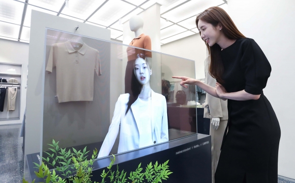 서울 마포구에 위치한 ‘무신사 스탠다드 홍대’에서 LG디스플레이 모델이 투명 OLED로 신상품 의류를 확인하고 있다.