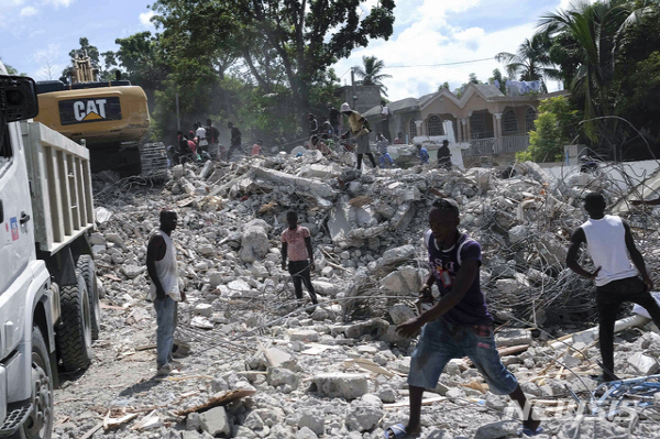 아이티 레카예에서 주민들이 지진으로 무너진 르망기에 호텔의 잔해를 치우고 있다. 뉴시스