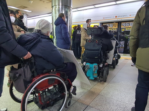 전장연 회원들이 2월 17일 충무로역 3호선 열차를 타기 위해 일렬로 대기하고 있다.<서창완>