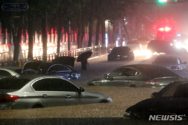 서울과 경기북부 등 수도권에 폭우가 내린 8일 오후 서울 강남구 일대 도로가 침수돼 차량이 잠겨 있다. 뉴시스