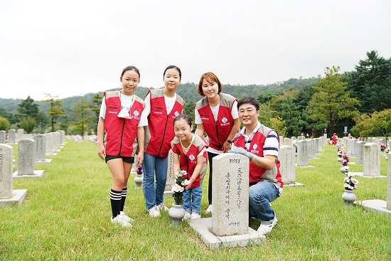 롯데건설 임직원과 가족들이 자매결연 묘역에서 봉사활동 후 기념촬영하고 있다.롯데건설