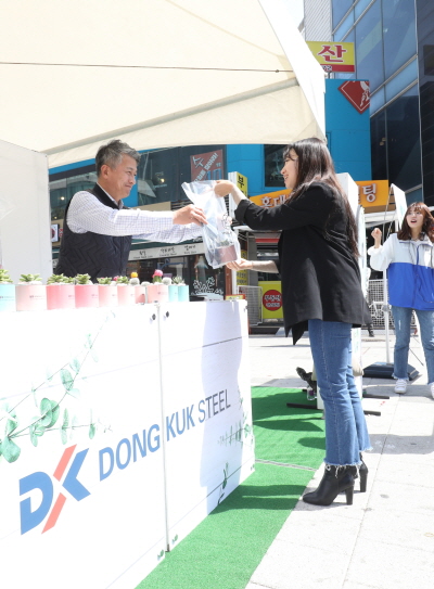 장세욱(왼쪽) 동국제강 부회장이 철의 친환경성을 홍보하기 위한 ‘그린 캠페인’ 일환으로 임직원들과 지난해 4월 15일 서울 마포에서 한 시민에게 철로 만든 미니 화분을 나눠주고 있다. 동국제강