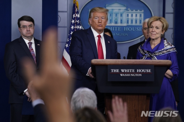 도널드 트럼프(가운데) 미국 대통령이 18일(현지시간) 백악관에서 신종 코로나바이러스 감염증(코로나19) 대응 태스크포스(TF) 기자회견을 진행하고 있다.AP·뉴시스