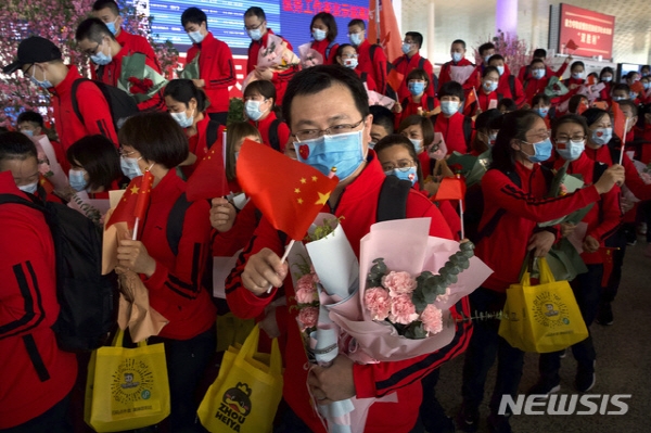 중국 지린성에서 우한으로 파견 나왔던 의료진이 8일 후베이성 우한의 우한 톈허 국제공항에서 배웅나온 우한 관계자들과 작별 인사를 하고 있다. 뉴시스