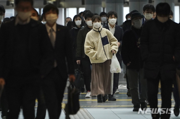 20일 월요일 러시아워를 맞은 일본 도쿄의 한 전철역 통로에서 시민들이 신종 코로나바이러스 감염증(코로나19) 예방을 위해 마스크를 쓴 채 걸어가고 있다.