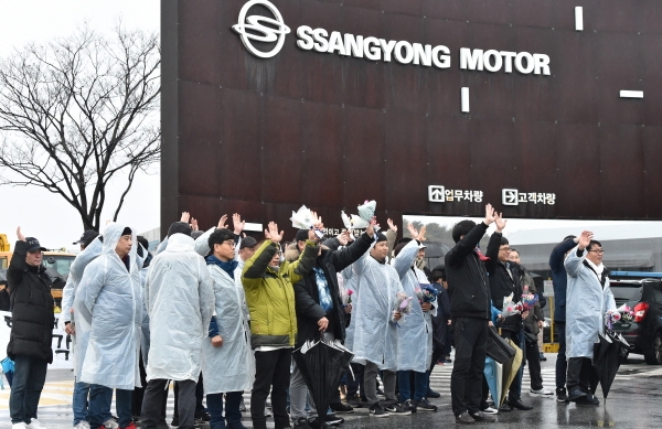 지난 1월 7일 쌍용자동차 해고 노동자 46명이 회사 정문 앞에서 '11년만의 출근 기자회견'을 마친 뒤 손을 흔들고 있다. 뉴시스