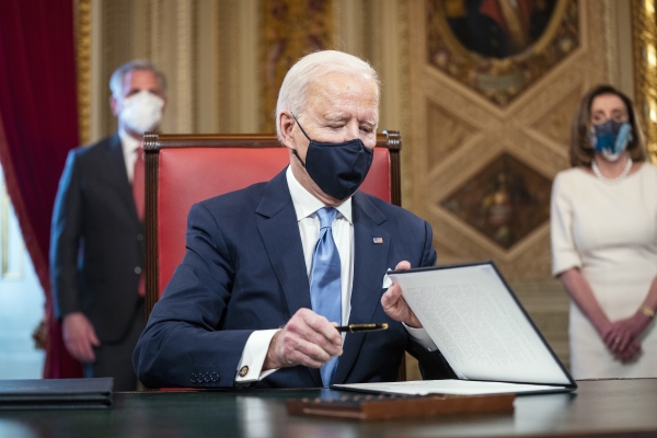 20일(현지시간) 취임한 조 바이든 미국 대통령이 의회의사당 대통령실에서 취임 선언문 등 3가지 문서에 서명을 하고 있다. 뉴시스