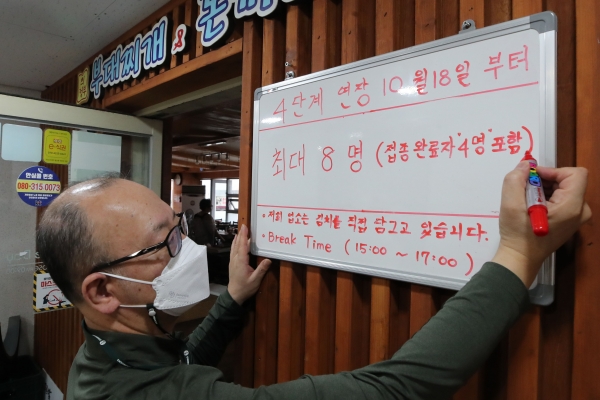 15일 오후 서울 종로구 한 식당점주가 조정된 사회적 거리두기에 따른 변경 인원을  안내하고 있다. 뉴시스