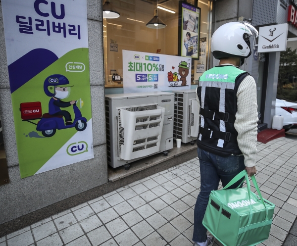 서울시내의 한 편의점에서 배달 업체 직원이 상품을 받아 편의점을 나서고 있다.