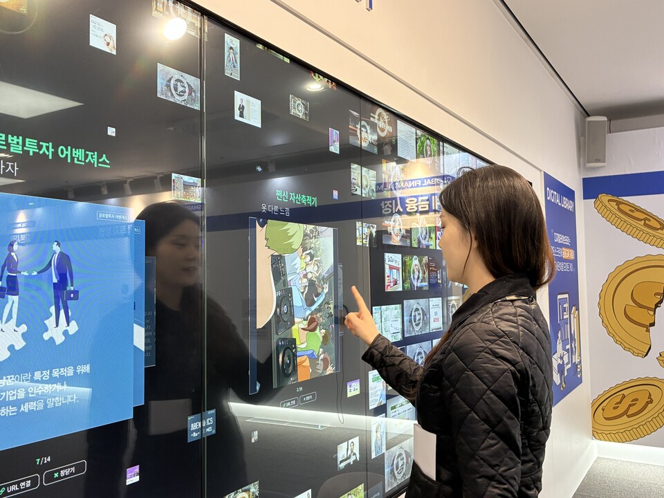 기자가 디지털 라이브러리에서 금융 관련 웹툰을 보고 있다.<최재아>